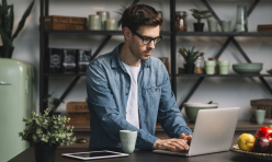 young-man-wearing-eyeglasses-using-laptop-kitchen-counter.jpg